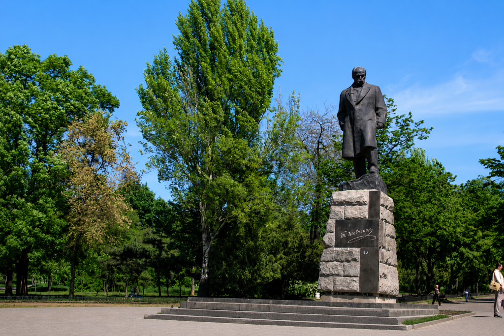 Цікаві факти про Тараса Шевченка та його життя Пам'ятник Тарасу Шевченку в Одесі, встановлений у зеленому міському парку серед дерев у сонячний день.